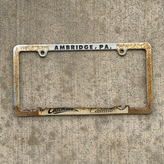 Photo of a 1980 Era Ambridge Oldsmobile Cadillac Pennsylvania License Plate Frame Auto Tag Garage Decor Vintage
 Metal with original patina