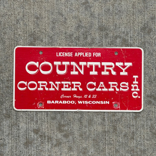 Photo of a 1980 Era Baraboo Wisconsin Booster License Plate Auto Tag Garage Decor Vintage Country Corner Cars Inc Paper with original patina