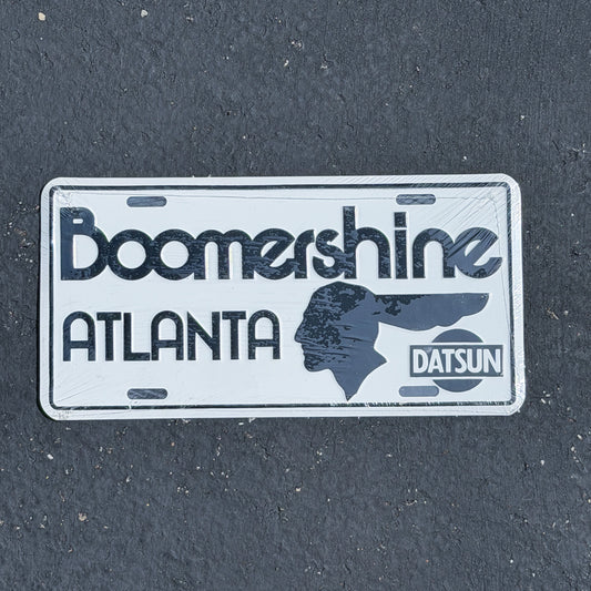 Photo of a 1980 Era Boomershine Datsun Atlanta Georgia Booster License Plate Auto Tag Garage Decor Vintage
 Metal NOS with original patina