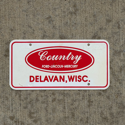 Photo of a 1980 Era Delavan Wisconsin Booster License Plate Auto Tag Garage Decor Vintage Country Ford Lincoln Mercury Plastic with original patina