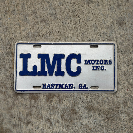 Photo of a 1980 Era Eastman Georgia Booster License Plate Auto Tag Garage Decor Vintage LMC Motors Inc Metal with original patina