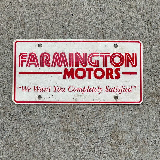 Photo of a 1980 Era Farmington Motors New Mexico Booster License Plate Auto Tag Garage Decor Vintage with original patina