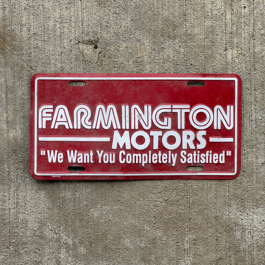 Photo of a 1980 Era Farmington Motors New Mexico Booster License Plate Auto Tag Garage Decor Vintage Metal with original patina