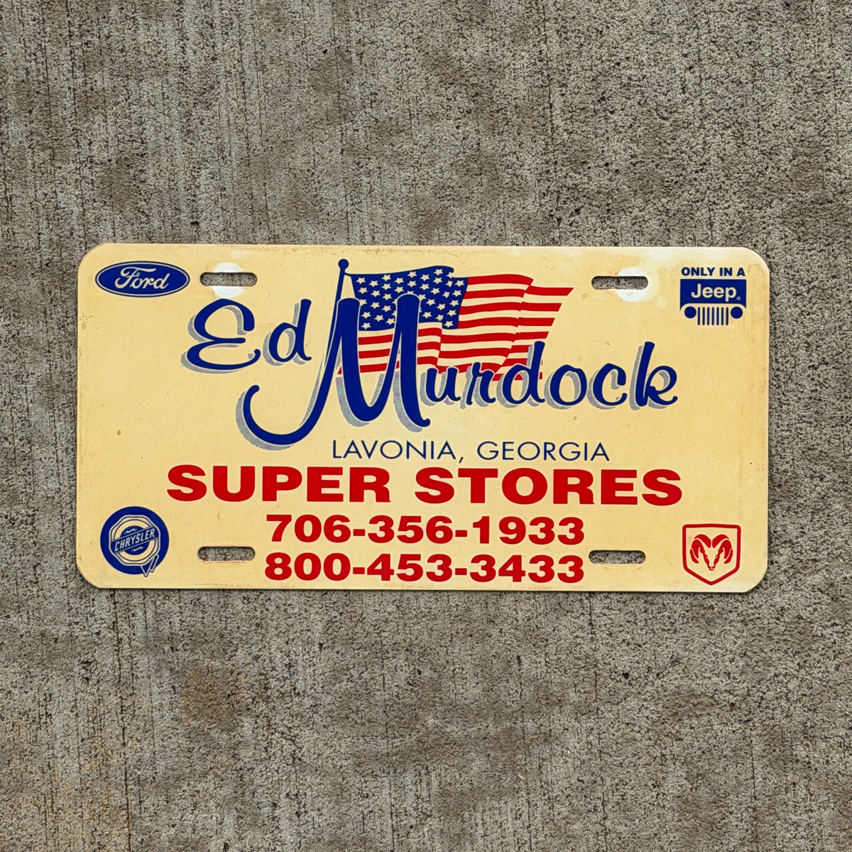Photo of a 1980 Era Lavonia Georgia Booster License Plate Auto Tag Garage Decor Vintage Murdock Super Stores Ford Jeep Dodge Chrysler Plastic with original patina