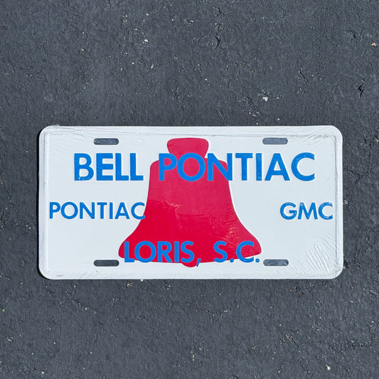 Photo of a 1980 Era Loris South Carolina Booster License Plate Auto Tag Garage Decor Vintage
 Bell Pontiac GMC NOS Metal with original patina
