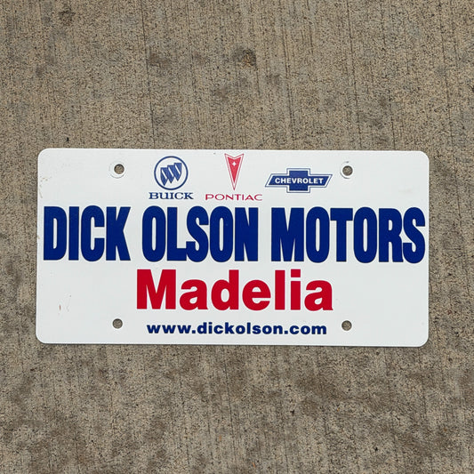 Photo of a 1980 Era Madelia Minnesota Booster License Plate Auto Tag Garage Decor Vintage Dick Olson Motors Buick Pontiac Chevy Plastic with original patina