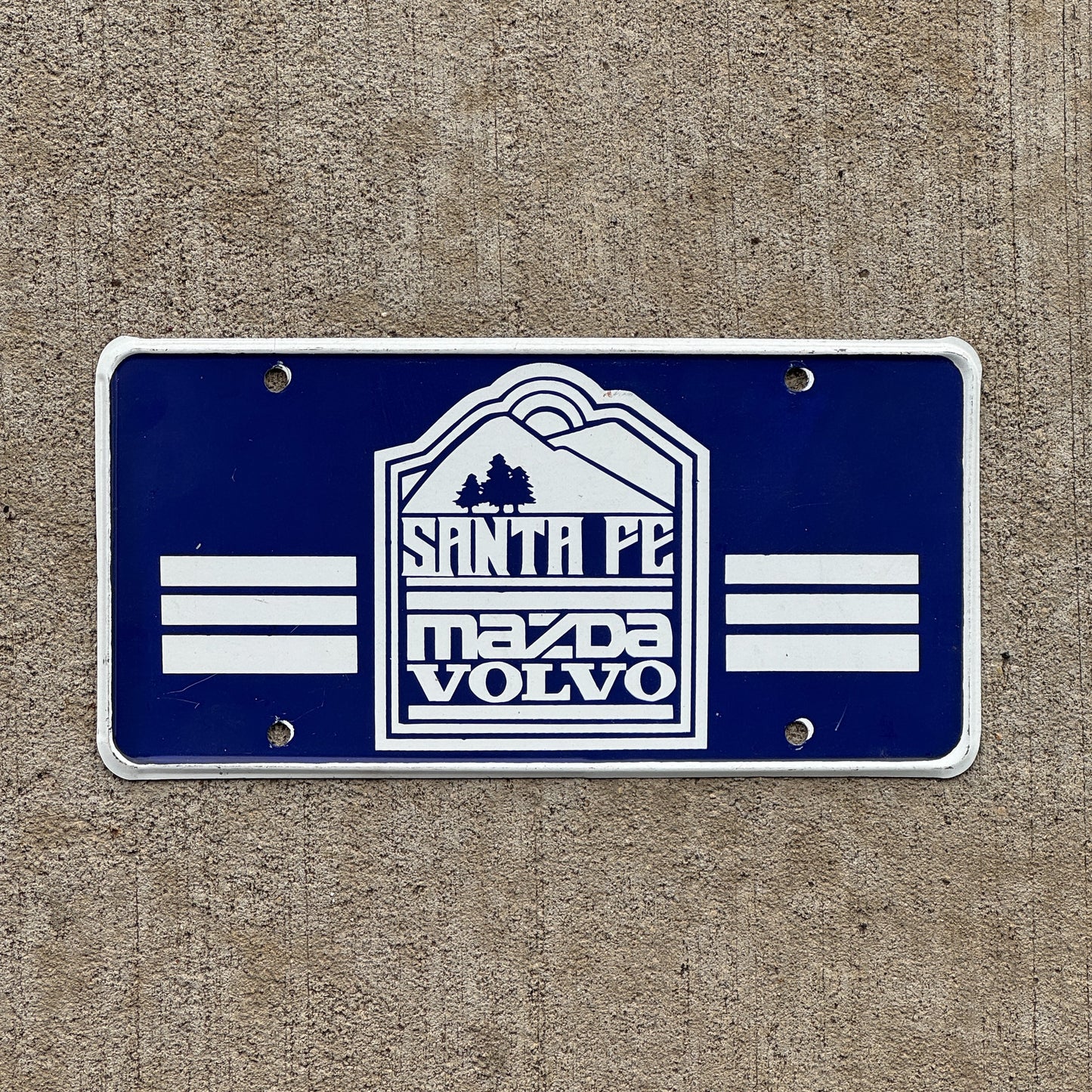Photo of a 1980 Era Santa Fe New Mexico Booster License Plate Auto Tag Garage Decor Vintage Mazda Volvo Metal with original patina