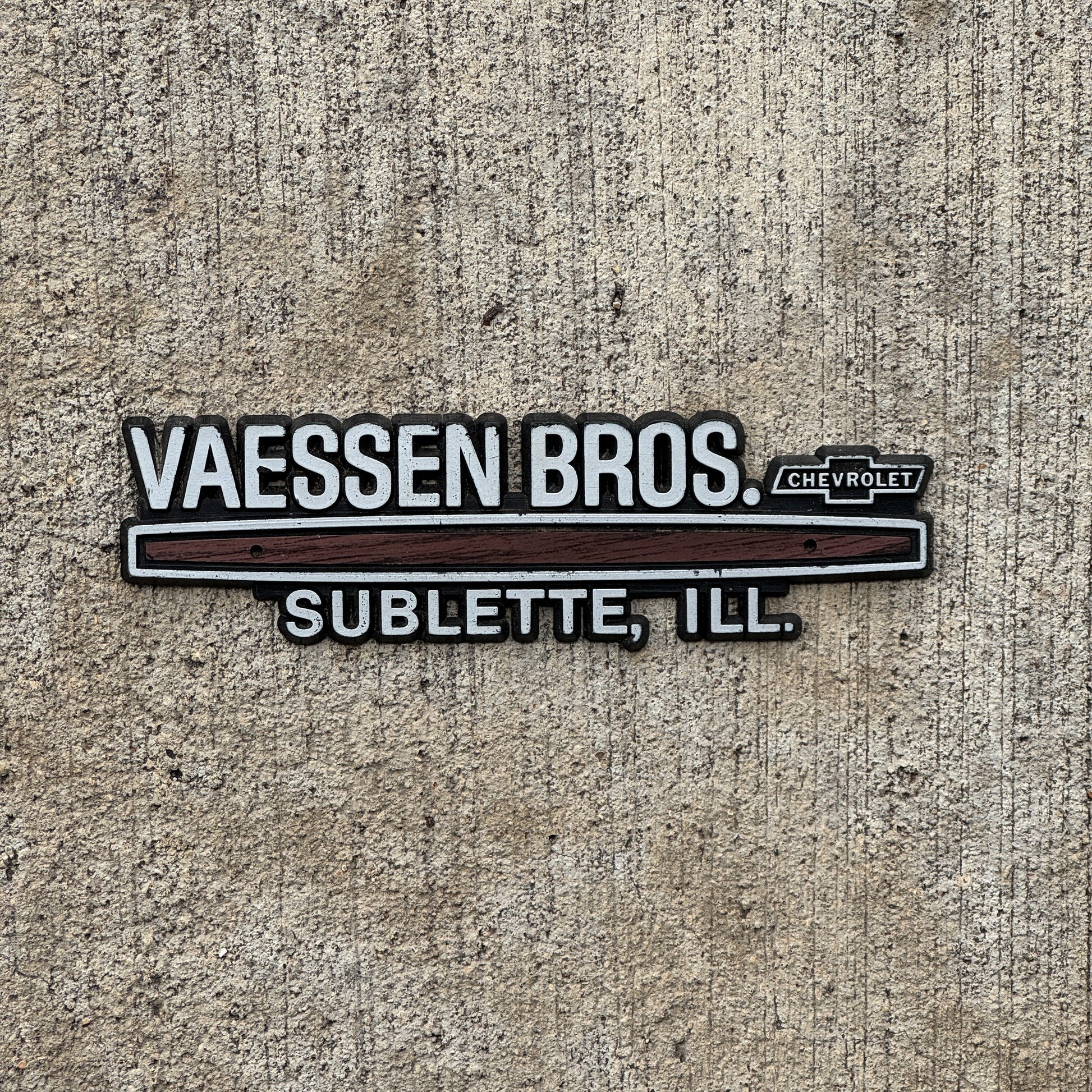 Photo of a 1980 Era Vassen Bros Sublette Illinois Dealer Badge Emblem Auto Tag Garage Decor Vintage Chevy Dealership with original patina