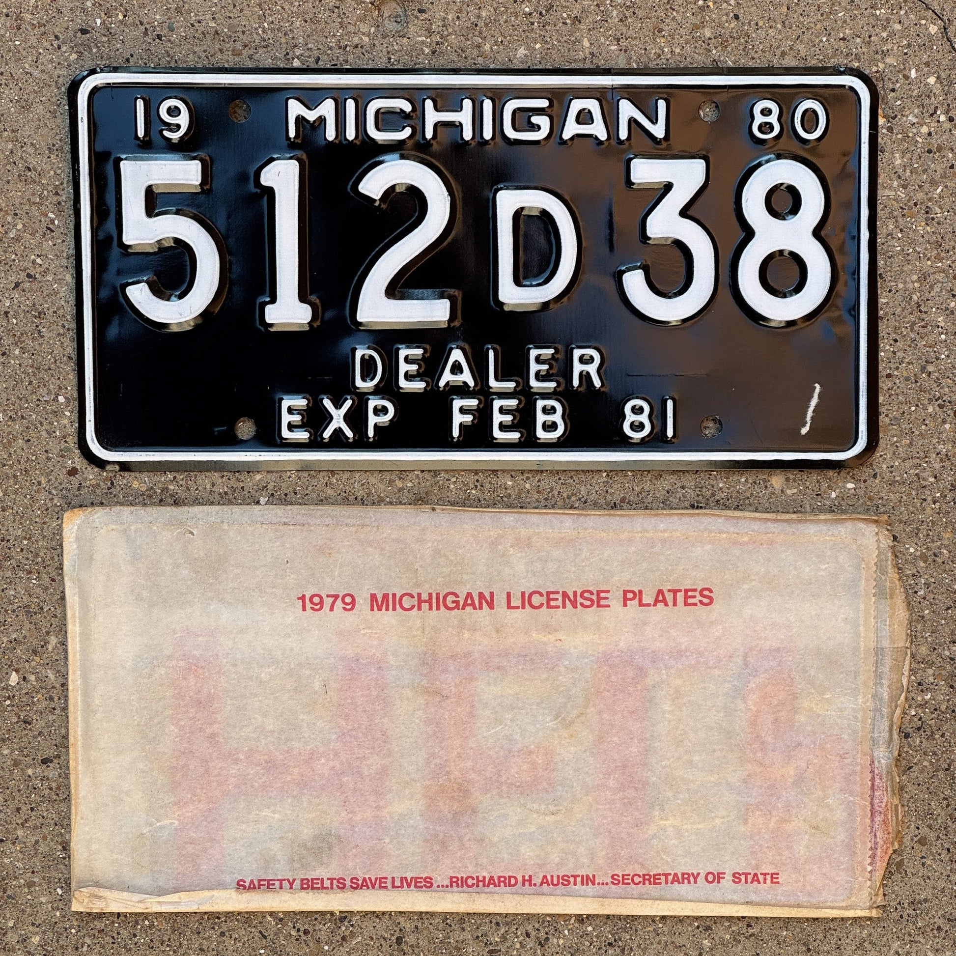 Photo of a 1980 Michigan Dealer License Plate Auto Tag Garage Decor Vintage NOS with envelope (non-matching) 512 D 38