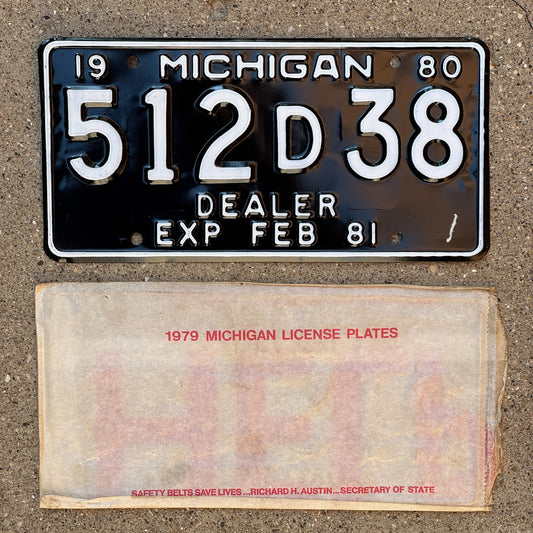 Photo of a 1980 Michigan Dealer License Plate Auto Tag Garage Decor Vintage NOS with envelope (non-matching) 512 D 38