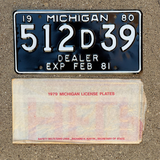 Photo of a 1980 Michigan Dealer License Plate Auto Tag Garage Decor Vintage NOS with envelope (non-matching) 512 D 39
