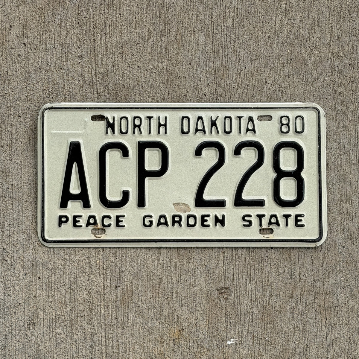 Photo of a 1980 North Dakota License Plate Auto Tag Garage Decor Vintage ACP 228 with original patina