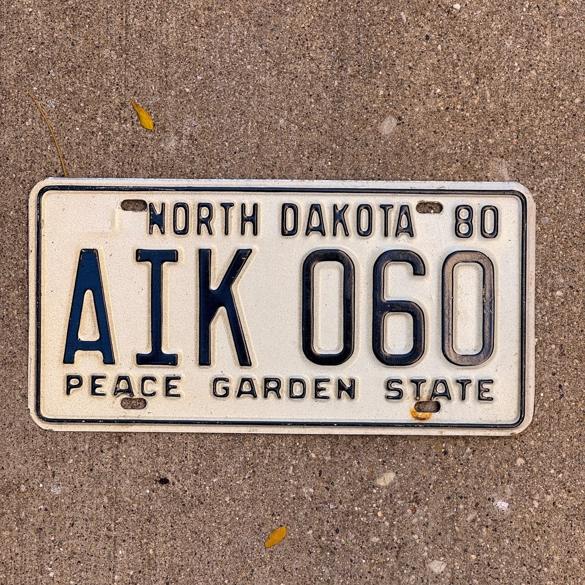 Photo of a 1980 North Dakota License Plate Auto Tag Garage Decor Vintage AIK 060 with original patina