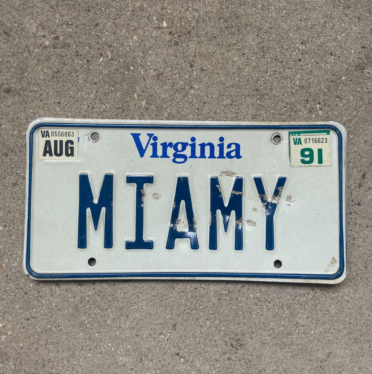 Virginia license plate with 'MIAMY' text on a concrete surface