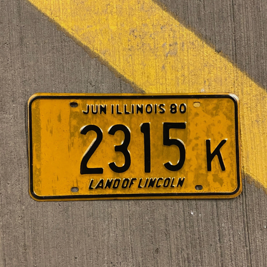 Yellow Illinois license plate with black text on a textured surface
