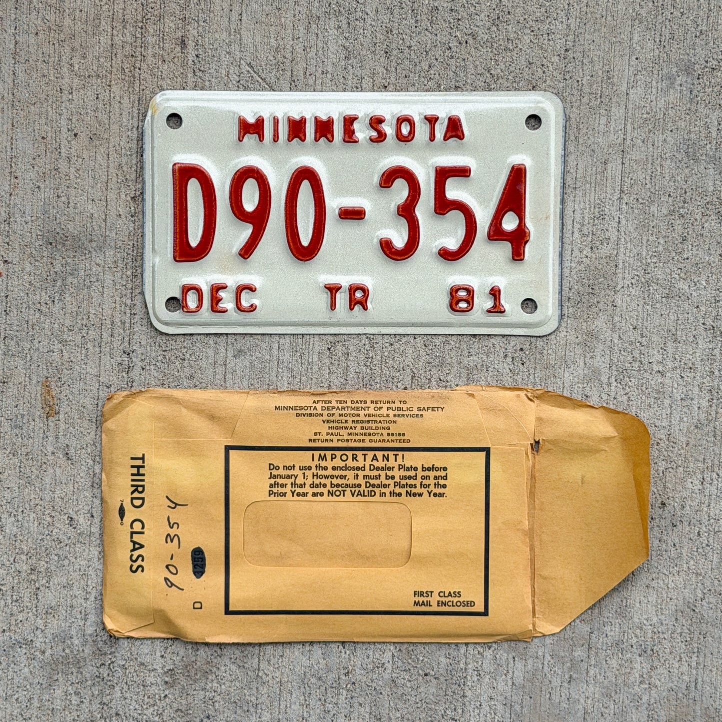 Photo of a 1981 Minnesota Trailer Dealer License Plate Auto Tag Garage Decor Vintage NOS with Envelope D90 354 with original patina