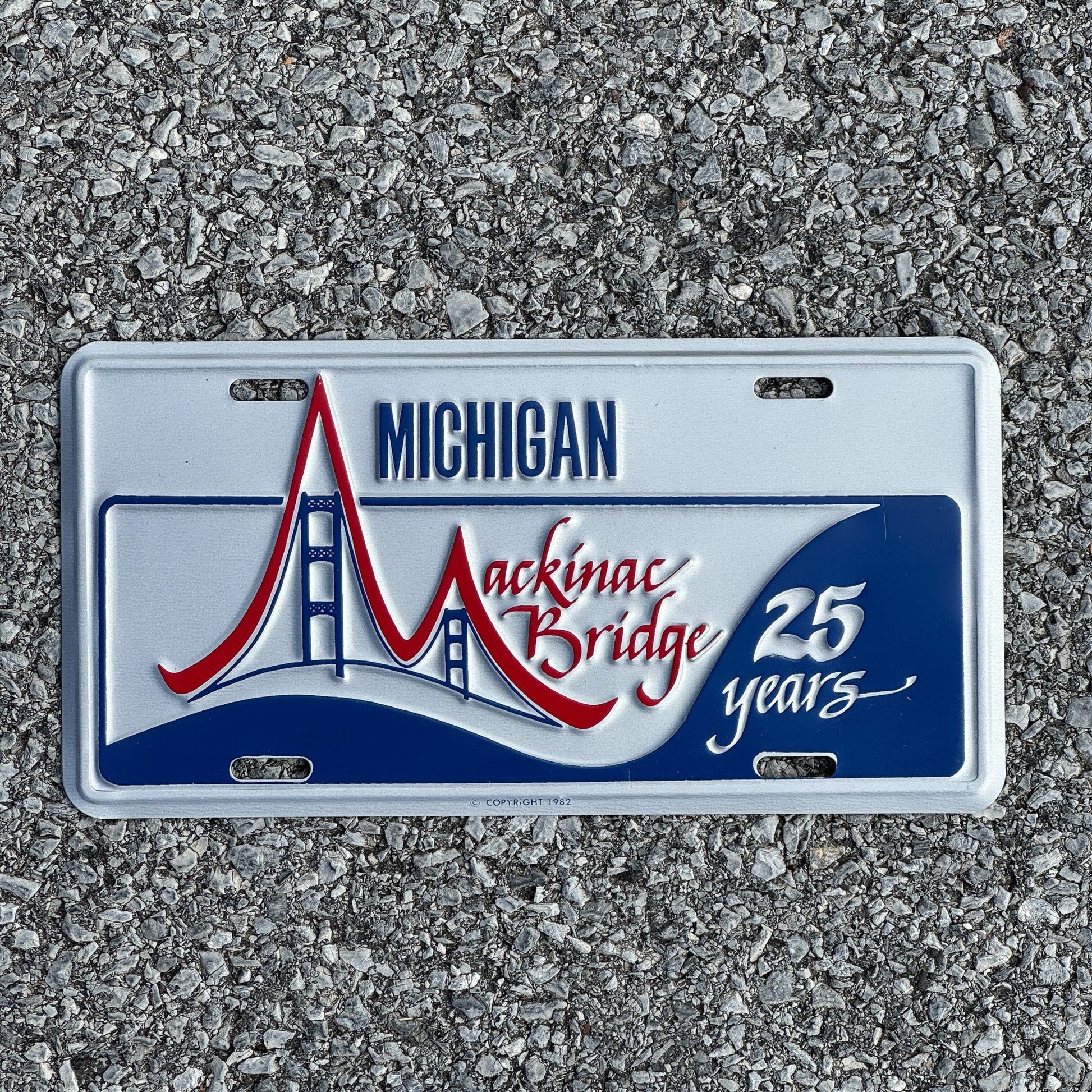Photo of a 1982 Michigan Booster License Plate Auto Tag Garage Decor Vintage Mackinac Bridge 25th Anniversary
