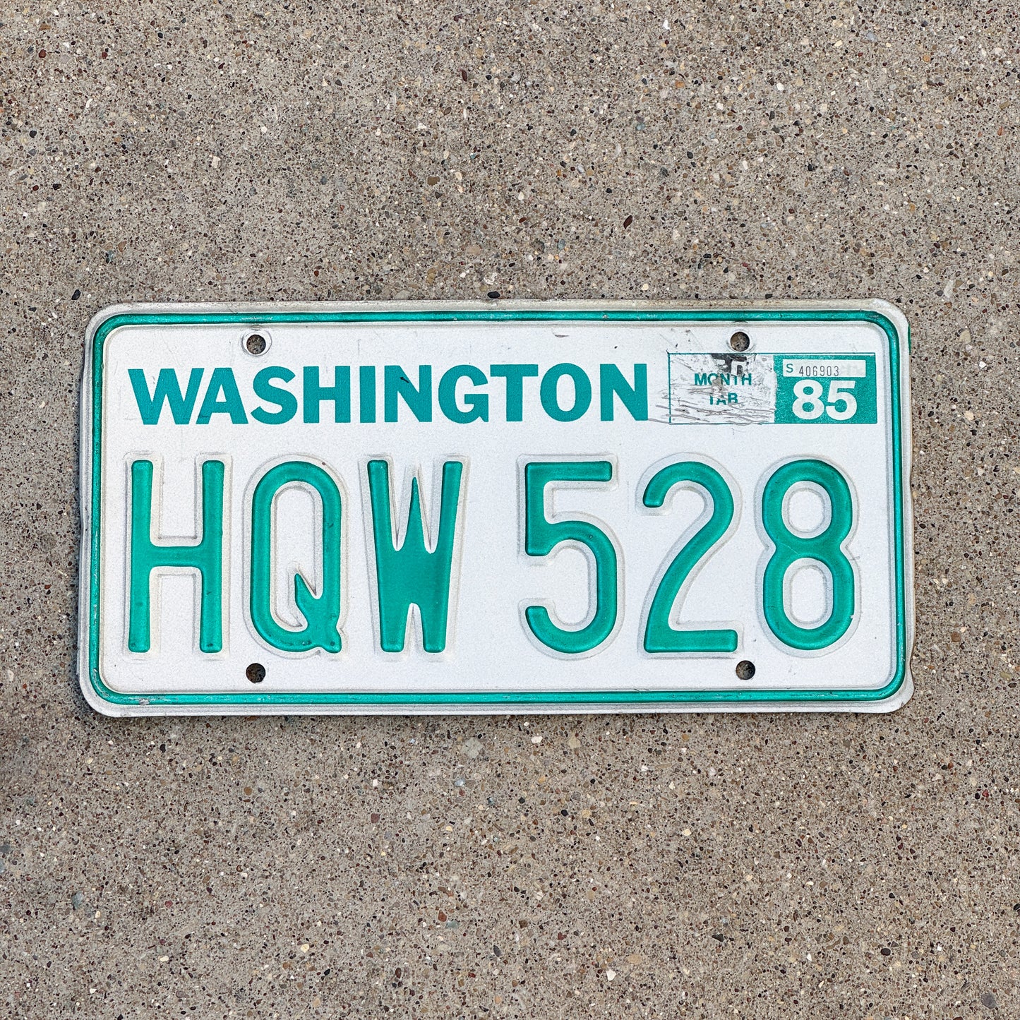 Photo of a 1983 1985 Washington License Plate Auto Tag Garage Decor Vintage DMV Clear Number HQW 528 with original patina