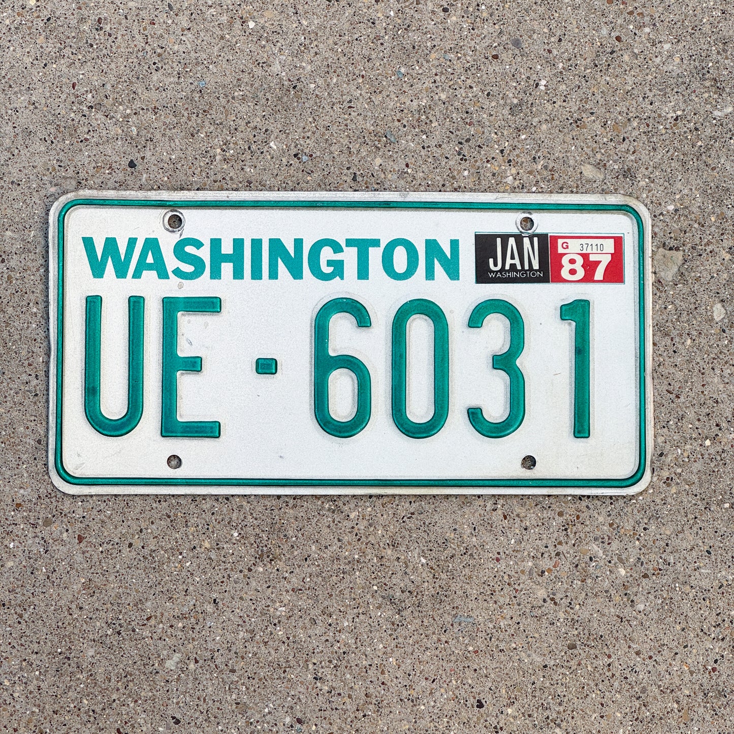 Photo of a 1983 1987 Washington Truck License Plate Auto Tag Garage Decor Vintage DMV Clear Number UE 6031 with original patina