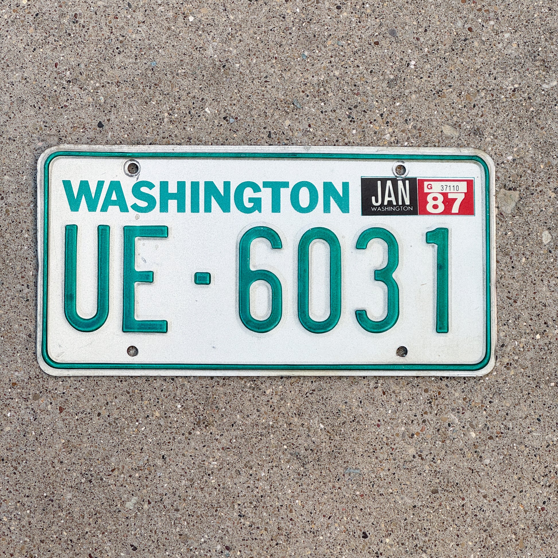 Photo of a 1983 1987 Washington Truck License Plate Auto Tag Garage Decor Vintage DMV Clear Number UE 6031 with original patina