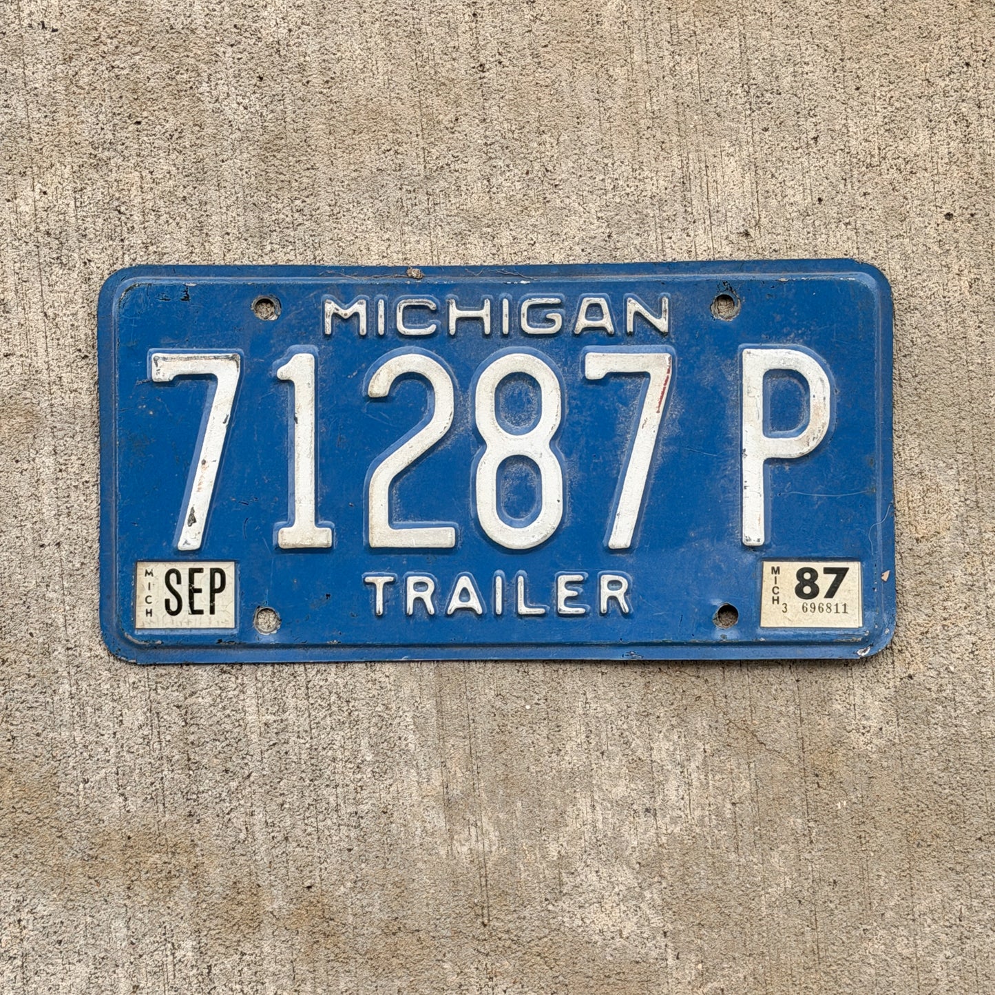 Photo of a 1984 1987 Michigan Trailer License Plate Auto Tag Garage Decor Vintage 71287 P with original patina