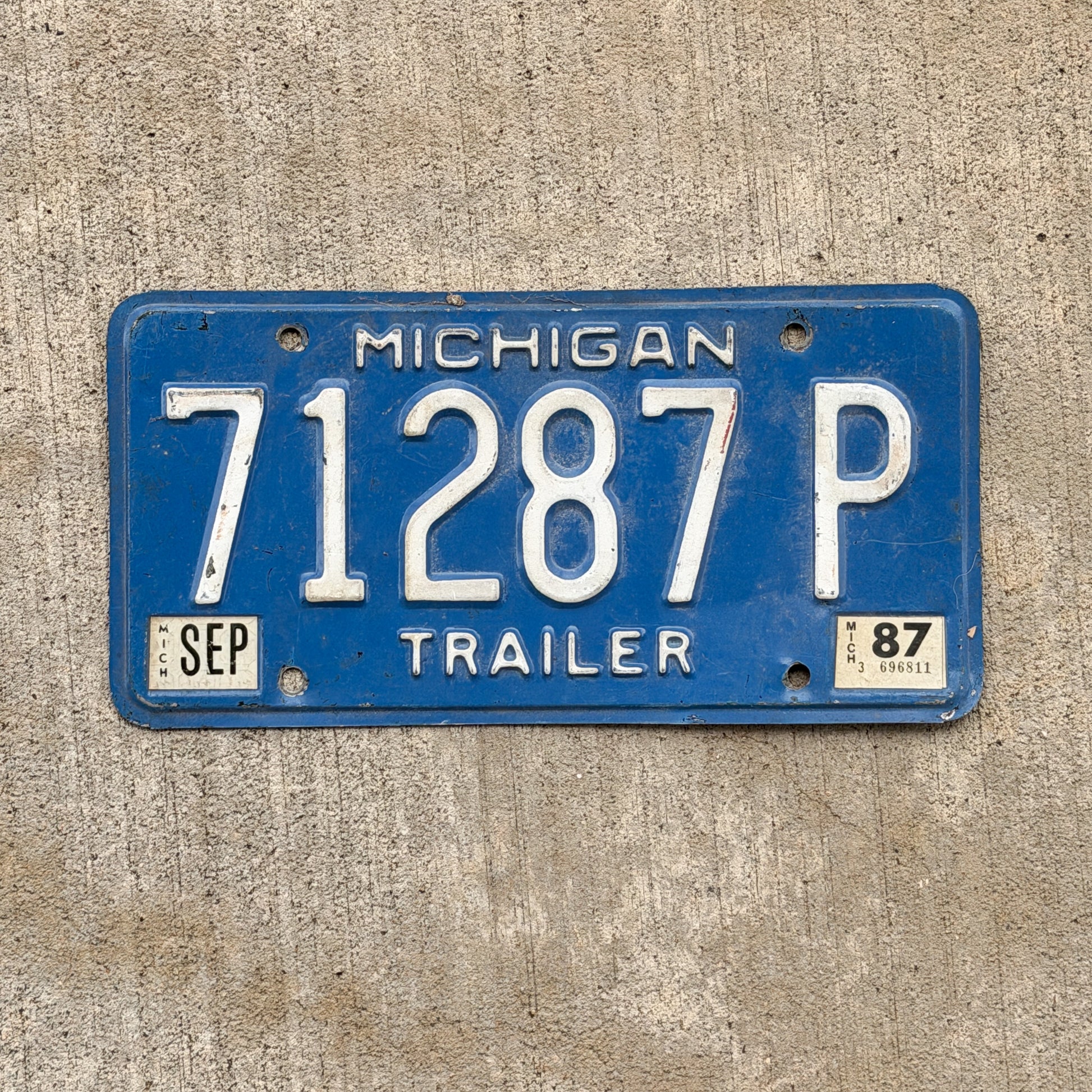Photo of a 1984 1987 Michigan Trailer License Plate Auto Tag Garage Decor Vintage 71287 P with original patina