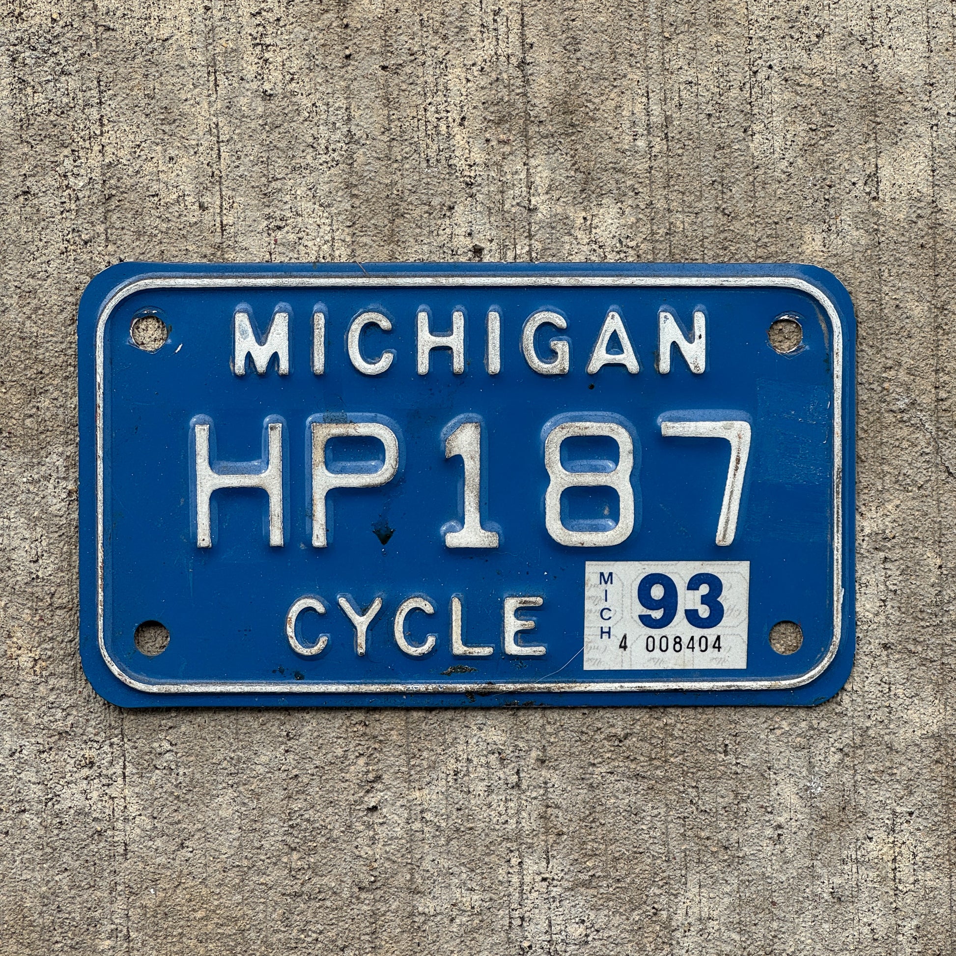 Photo of a 1984 1993 Michigan Motorcycle License Plate Auto Tag Garage Decor Vintage HP 187 with original patina