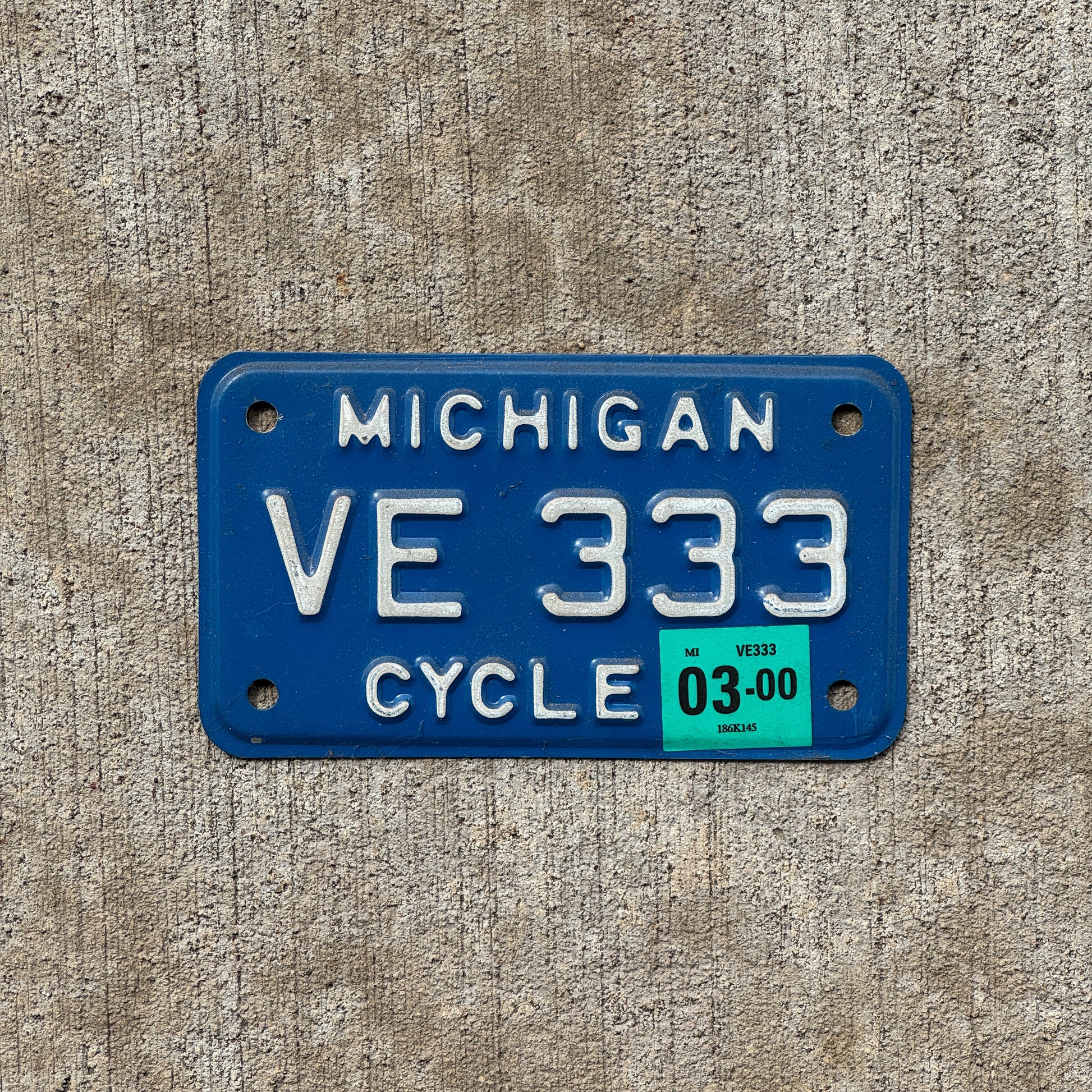 Photo of a 1984 2000 Michigan Motorcycle License Plate Auto Tag Garage Decor Vintage Repeat Repeating VE 333 with original patina