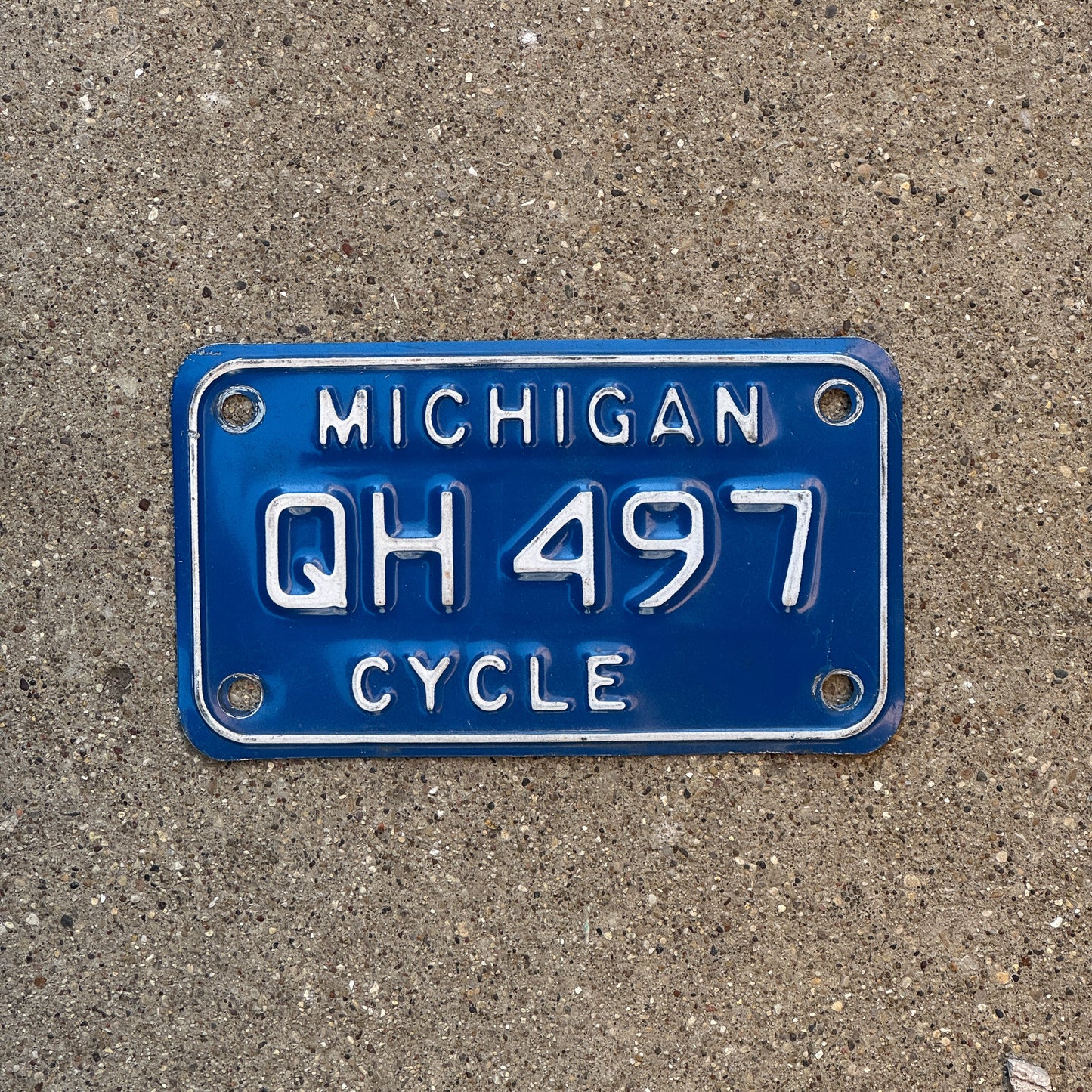 Photo of a 1984 Michigan Motorcycle License Plate Auto Tag Garage Decor Vintage QH 497 with original patina