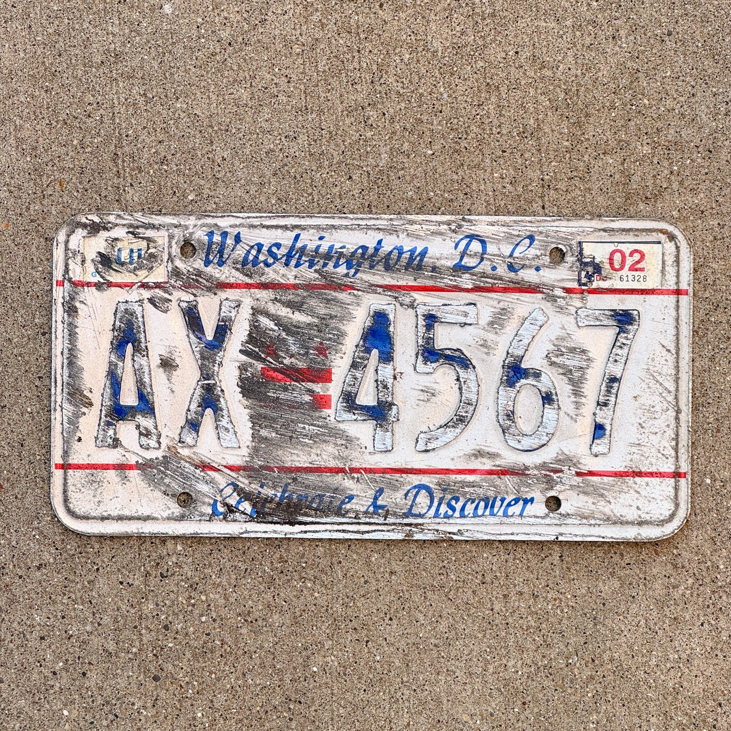Photo of a 1985 2002 Washington DC License Plate Auto Tag Garage Decor Vintage Celebrate and Discover AX 4567 with original patina