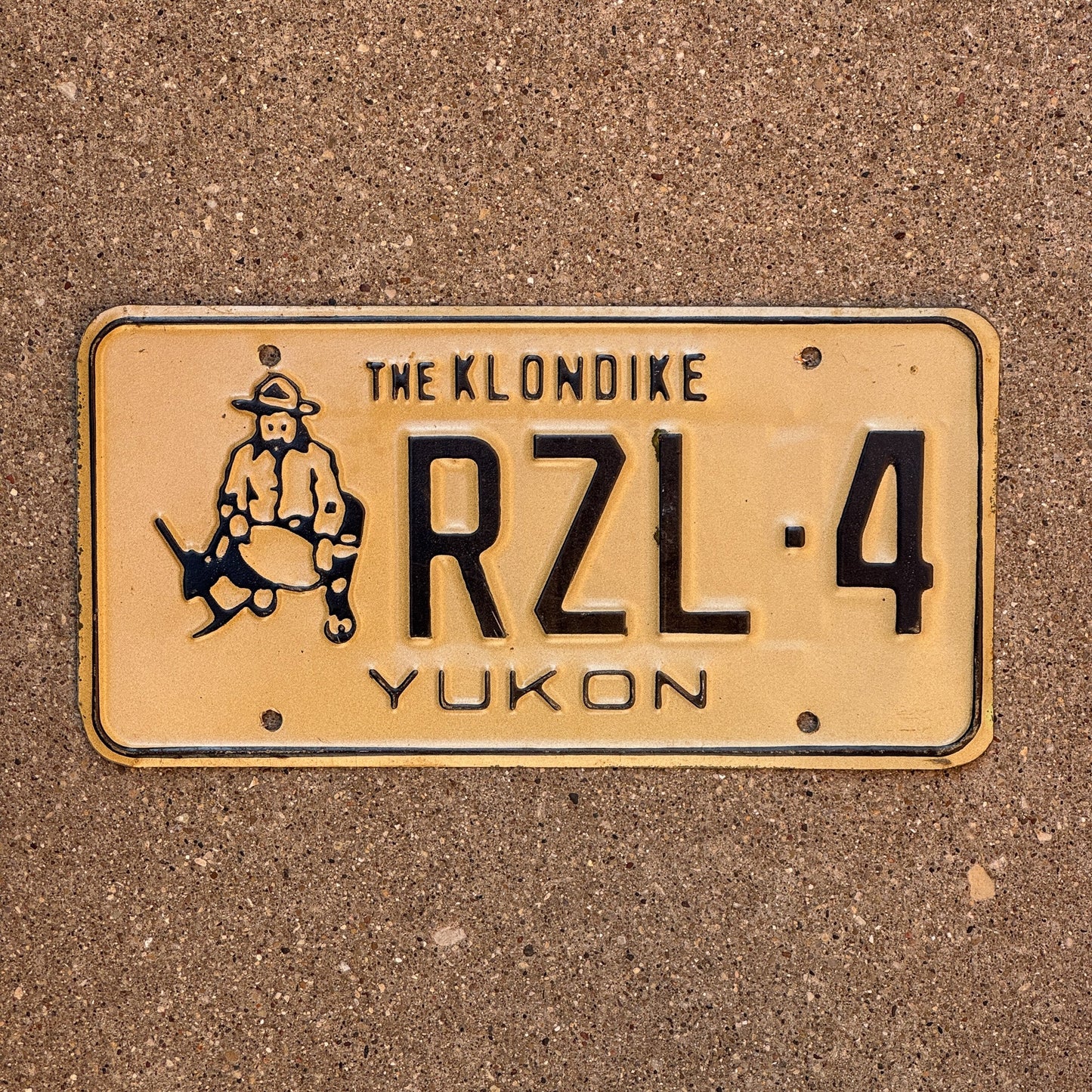 Photo of a 1985 Yukon License Plate Auto Tag Garage Decor Vintage Gold Prospector Graphic RZL 4