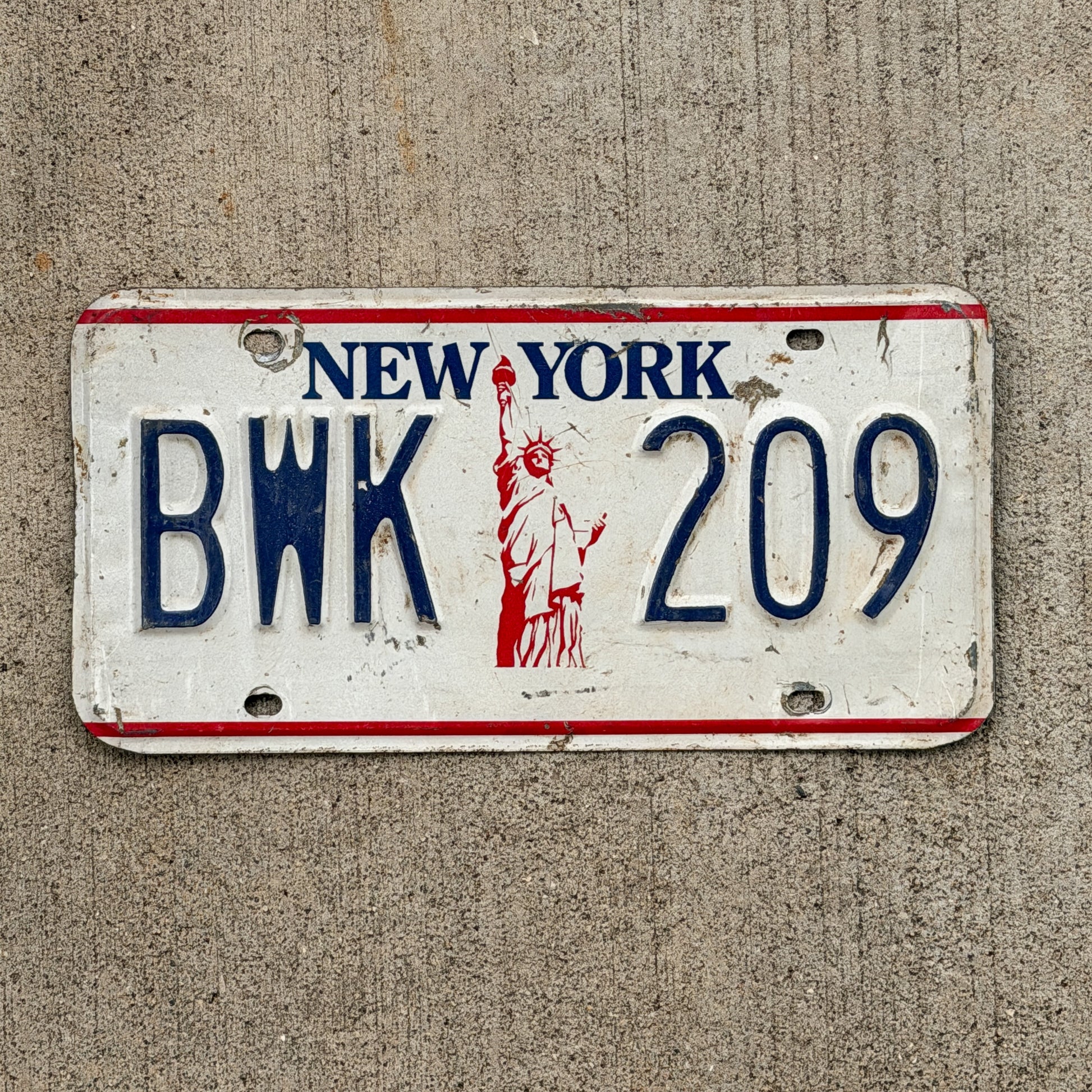 Photo of a 1986 New York License Plate Auto Tag Garage Decor Vintage Liberty Base BWK 209 with original patina