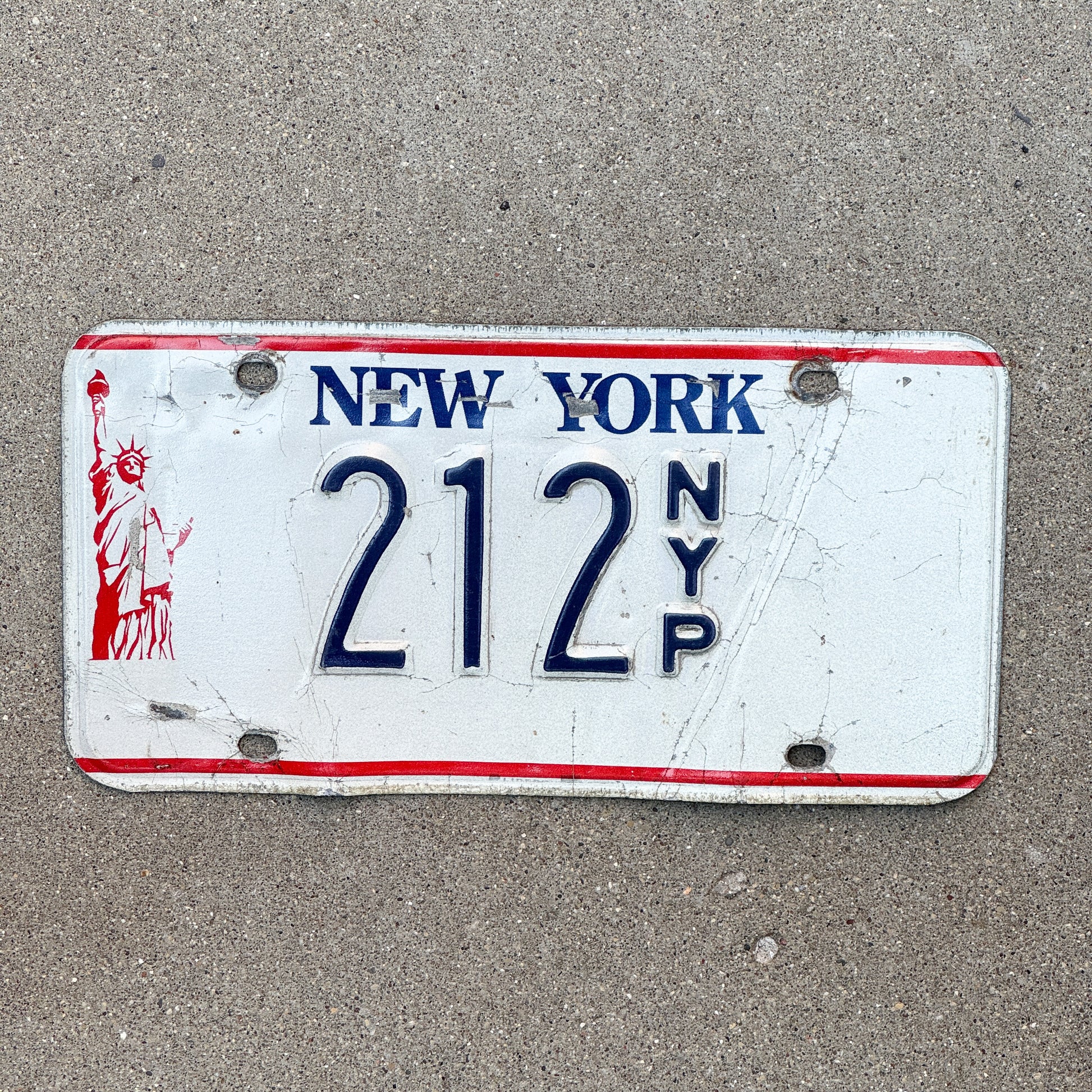 Photo of a 1986 New York Press License Plate Auto Tag Garage Decor Vintage News Newspaper 212 with original patina