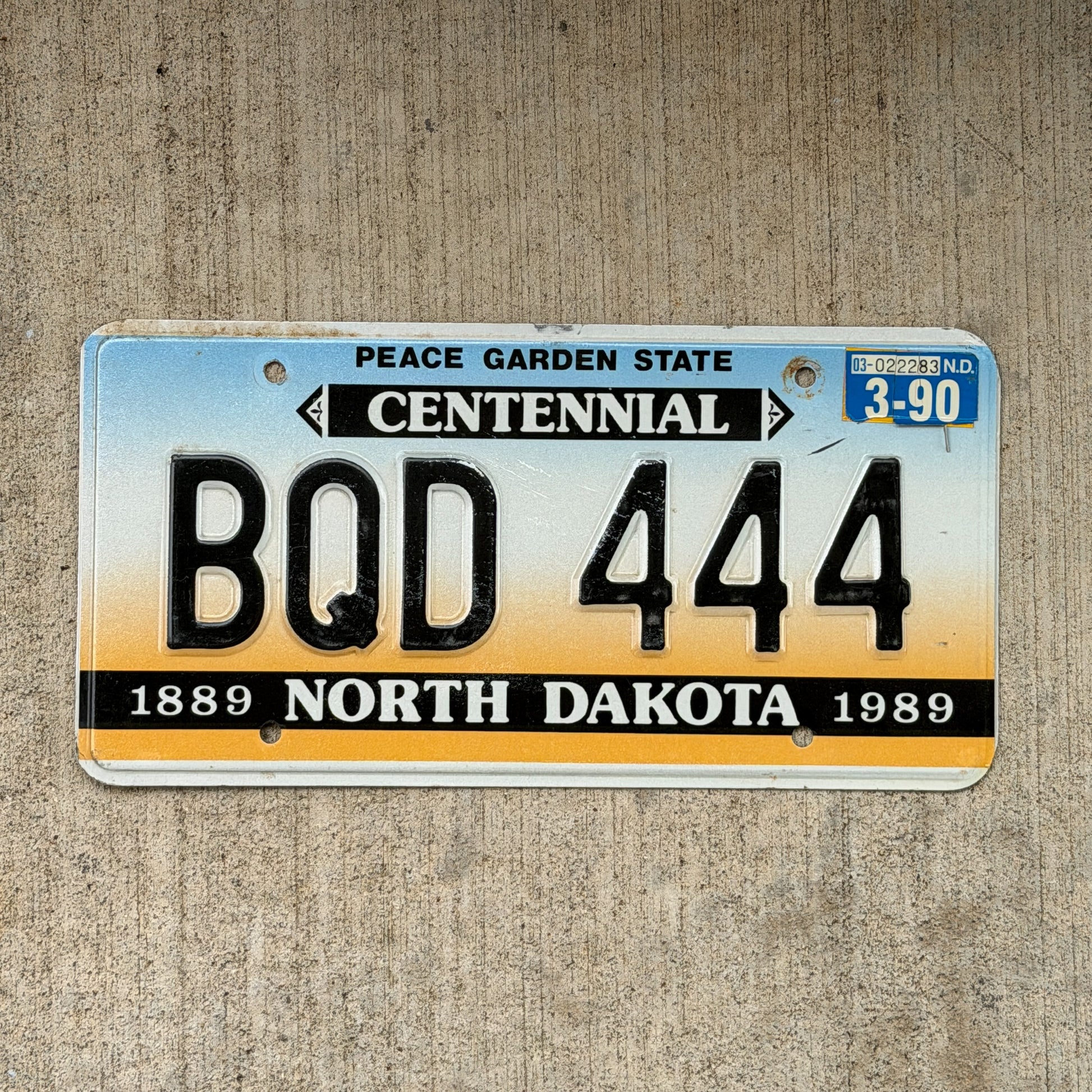 Photo of a 1987 1990 North Dakota License Plate Auto Tag Garage Decor Vintage Centennial Repeat Repeating BQD 444 with original patina