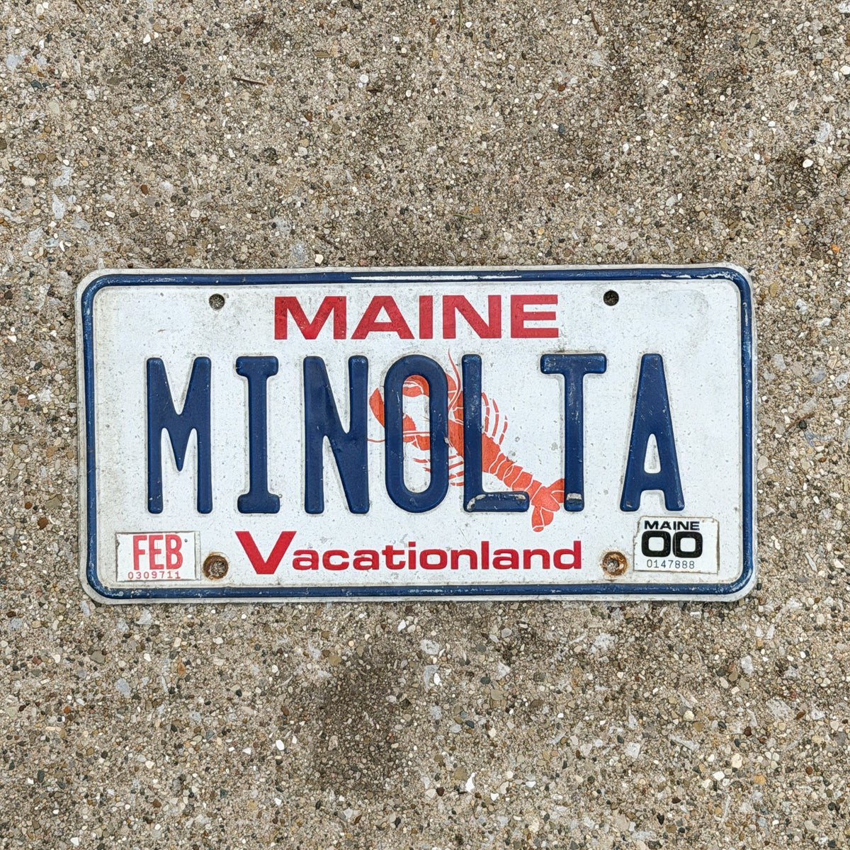 Photo of a 1987 2000 Maine Vanity License Plate Auto Tag Garage Decor Vintage Camera Film Photography MINOLTA with original patina