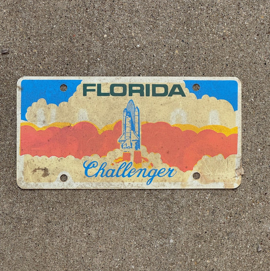 Photo of a 1987 Florida Booster License Plate Auto Tag Garage Decor Vintage Space Shuttle Plastic Cape Canaveral Challenger with original patina