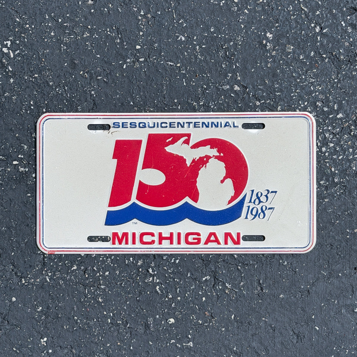Photo of a 1987 Michigan Booster License Plate Auto Tag Garage Decor Vintage
 Commemorative 150 Sesquicentennial Metal with original patina