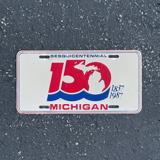 Photo of a 1987 Michigan Booster License Plate Auto Tag Garage Decor Vintage
 Commemorative 150 Sesquicentennial Metal with original patina