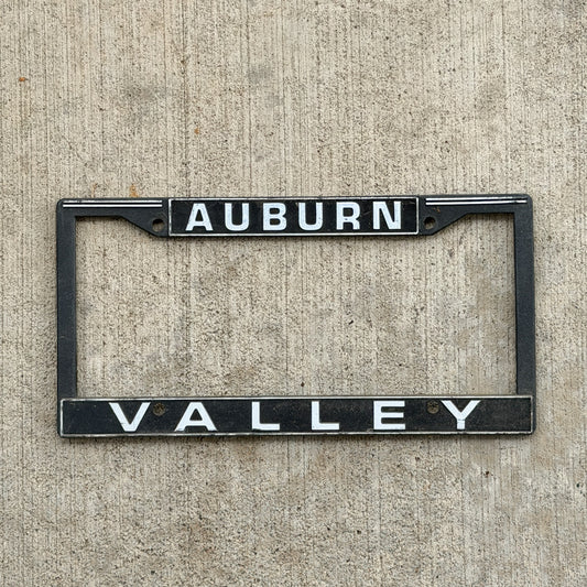 Photo of a 1990 Era Auburn Washington Dealer License Plate Frame Auto Tag Garage Decor Vintage
 Plastic Valley Motors with original patina