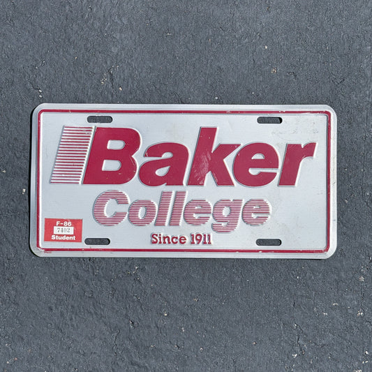 Photo of a 1990 Era Baker College Michigan Booster License Plate Auto Tag Garage Decor Vintage
 Metal with original patina