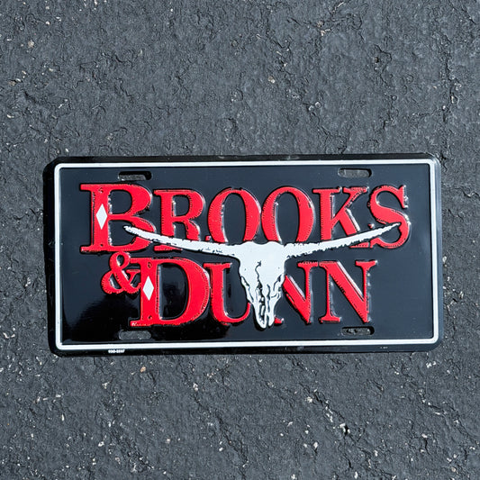Photo of a 1990 Era Brooks & Dunn Booster License Plate Auto Tag Garage Decor Vintage
 Country Music Cow Skull Metal with original patina