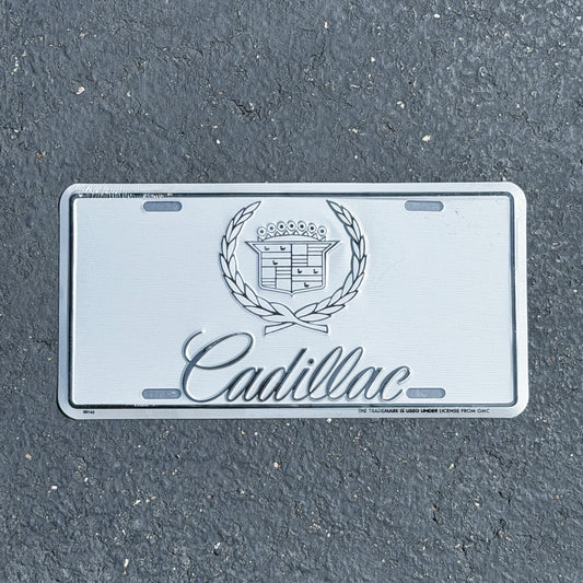 Photo of a 1990 Era Cadillac Booster License Plate Auto Tag Garage Decor Vintage
 Metal NOS with original patina