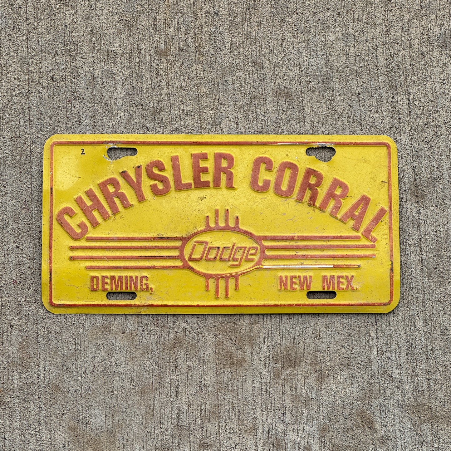 Photo of a 1990 Era Chrysler Corral Deming New Mexico Booster License Plate Auto Tag Garage Decor Vintage Dodge Metal with original patina