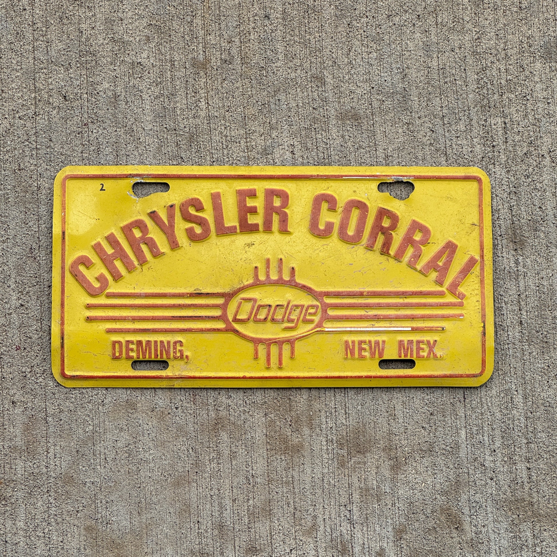 Photo of a 1990 Era Chrysler Corral Deming New Mexico Booster License Plate Auto Tag Garage Decor Vintage Dodge Metal with original patina