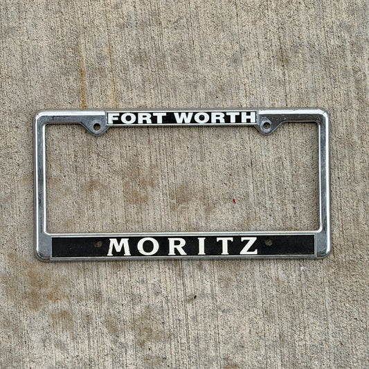 Photo of a 1990 Era Fort Worth Texas Dealer License Plate Frame Auto Tag Garage Decor Vintage
 Plastic Moritz Chevy with original patina