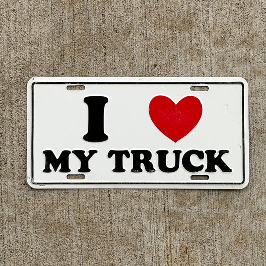 Photo of a 1990 Era I Love My Truck Booster License Plate Auto Tag Garage Decor Vintage
 Metal with original patina