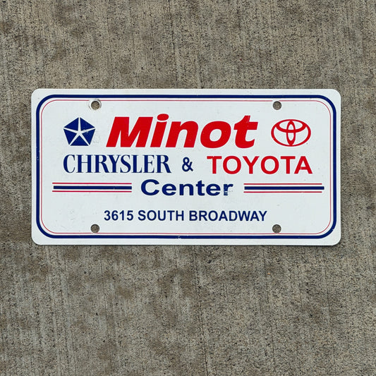 Photo of a 1990 Era Minot North Dakota Booster License Plate Auto Tag Garage Decor Vintage Chrysler Toyota Plastic with original patina