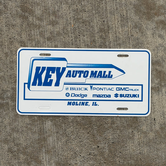 Photo of a 1990 Era Moline Illinois Booster License Plate Auto Tag Garage Decor Vintage Key Auto Mall Plastic with original patina
