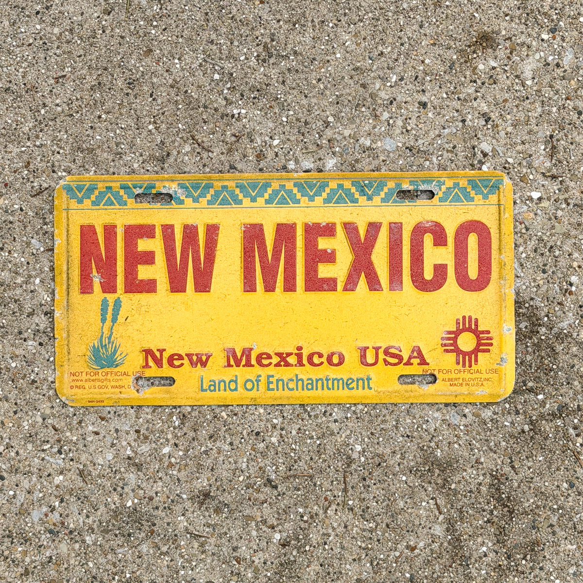 Photo of a 1990 Era New Mexico Booster License Plate Auto Tag Garage Decor Vintage Land of Enchantment Metal with original patina
