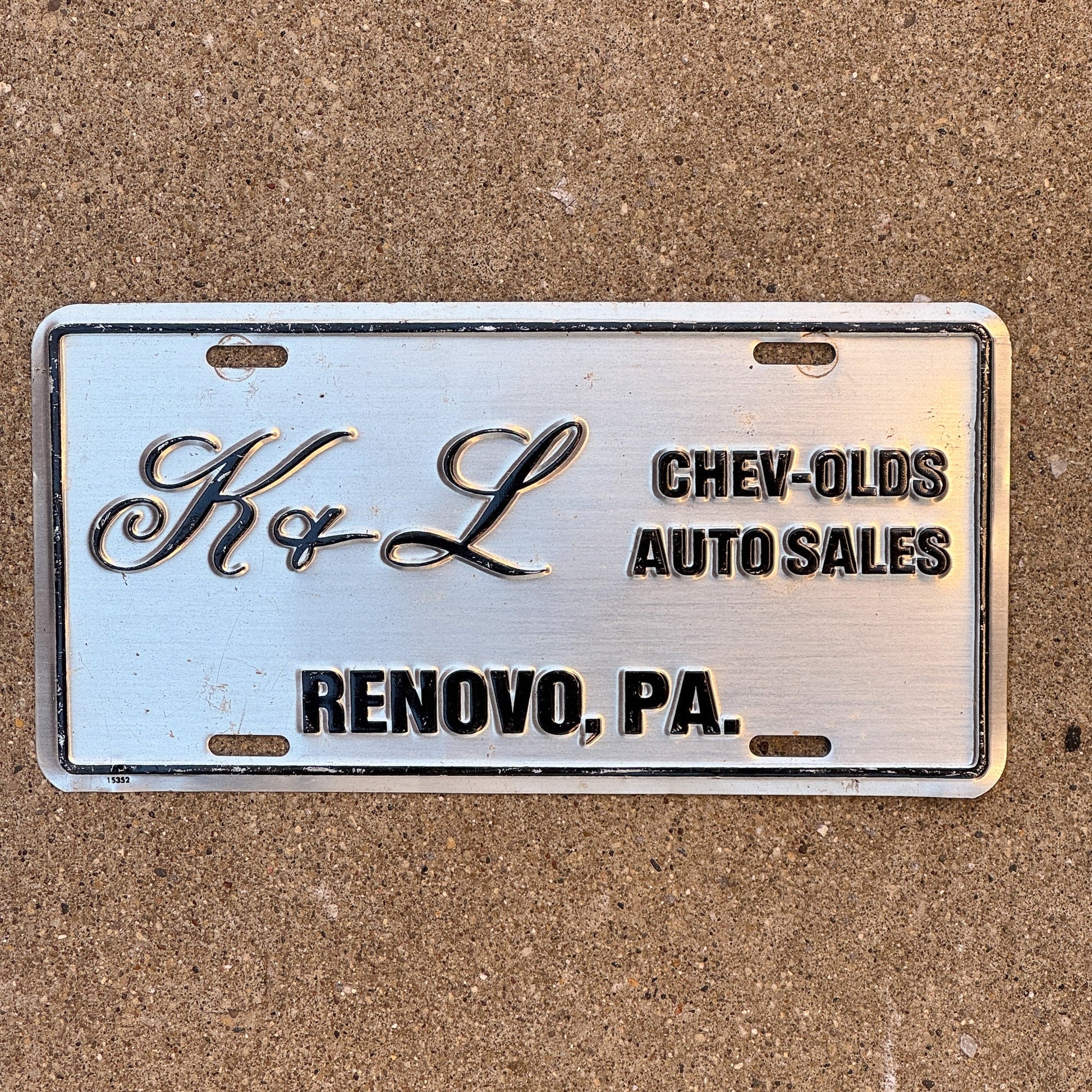 Photo of a 1990 Era Pennsylvania Dealer License Plate Booster License Plate Auto Tag Garage Decor Vintage Renovo Metal K & L Chevy Oldsmobile with original patina